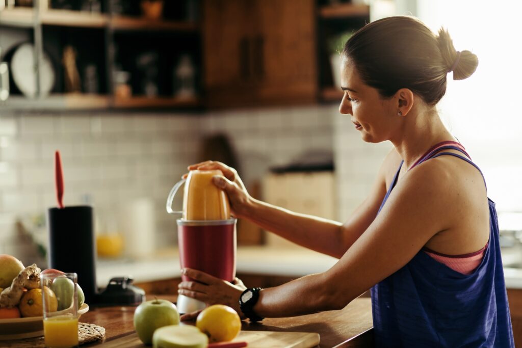 woman making her homemade recovery drinks post-workout